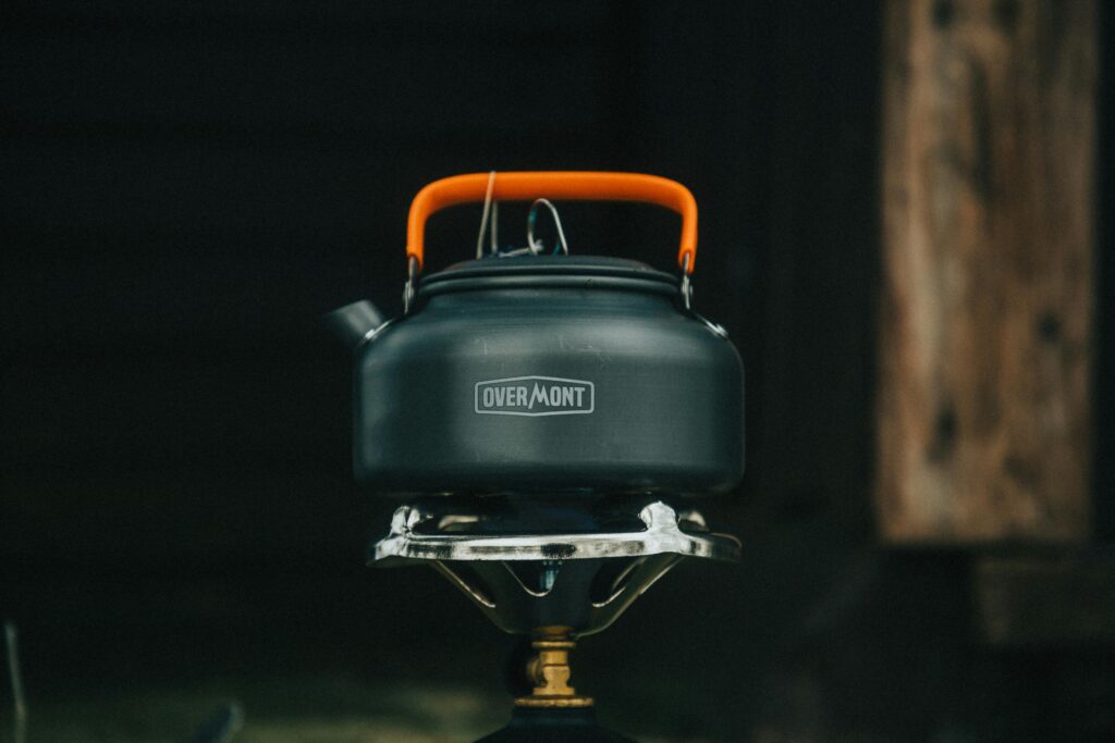 What Not to Bring on a Bikepacking Trip (Real Mistakes) A compact camping kettle sitting on a portable stove, ideal for outdoor adventures.