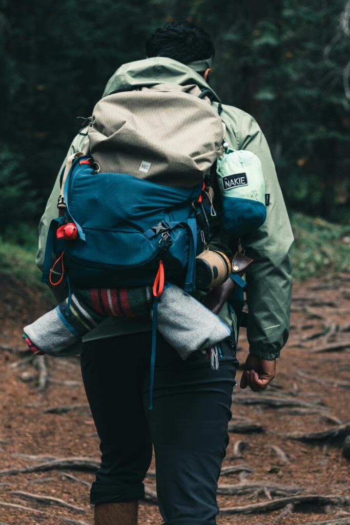 The Lightweight Bikepacking Checklist I’d Actually Recommend Rear view of a hiker carrying a backpack on a forest trail in Canada.